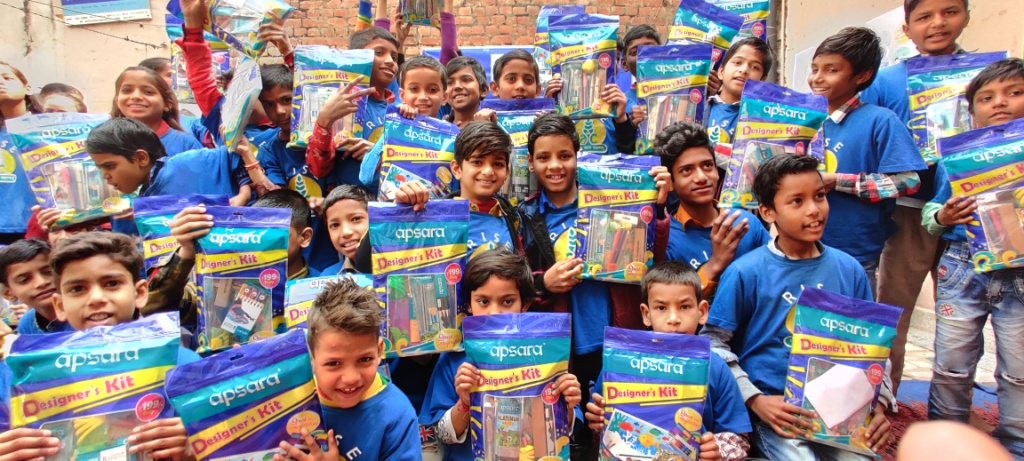 Children happily showing off their gifts given by ORACLE Team